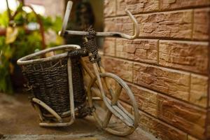 blomma i korg av årgång gammal cykel nära årgång trä- sommar gata Kafé i Europa foto