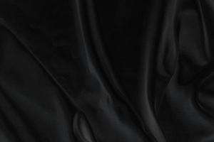 slät elegant svart silke tyg eller satin lyx trasa textur för abstrakt bakgrund foto