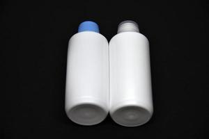 plast vit ampuller på en svart bakgrund. plast flaskor. vit plast behållare. foto