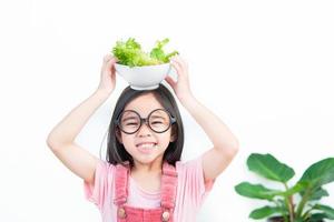 barn flicka Asien äter grönsaker foto