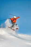 fripassagerare skidåkare hoppar in i djup snö foto