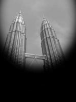 kuala lumpur-2016-02-28, retro svart bild vertikal, mörk himmel ovan topp av petronas tvilling torn. februari i kuala lumpur, malaysia. foto