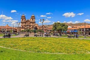 torg de armas huvud fyrkant med katedral och gul blommor i förgrund, cuzco, peru foto