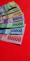 porträtt av indonesiska rupiah. samling av sedlar indonesiska rupiah isolerat på röd bakgrund. foto