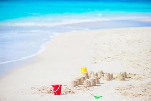 korthus på vit tropisk strand med plast barn leksaker foto