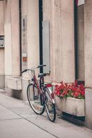 skön stad landskap med en cykel nära de gammal vägg med blommor i wien foto