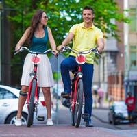 ung Lycklig caucasian par på Cyklar i amsterdam foto