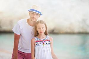 liten flicka och Lycklig pappa har roligt under strand semester foto