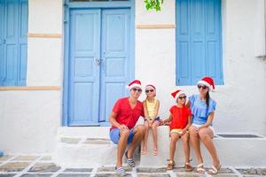 familj på xmas semester. föräldrar och barn på smal gata i traditionell grekisk by fira jul och ny år foto