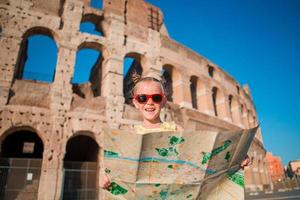 förtjusande liten aktiva flicka med Karta i främre av colosseum i rom, Italien. unge utgifterna barndom i Europa foto