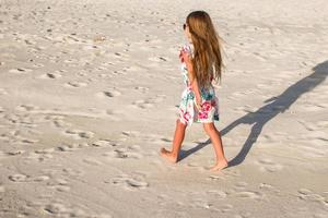 Lycklig liten flicka på strand under sommar semester foto