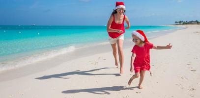 ung mor och liten flicka löpning på tropisk strand foto