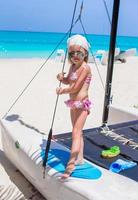 förtjusande liten flicka ha roligt på en Yacht under karibiska semester foto