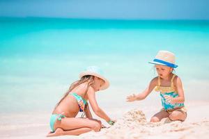 liten flickor på de strand under sommar semester foto