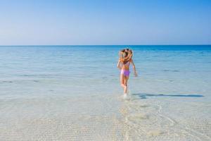 bedårande aktiv liten flicka på stranden under sommarlovet foto