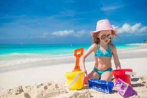 förtjusande liten flicka spelar med strand leksaker under carribean semester foto