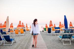 ung kvinna på de strand i europeisk semester på de ligurian kust i solnedgång foto