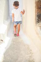 förtjusande flicka gående ensam i smal gator av emporio by på de ö Santorini, Grekland foto