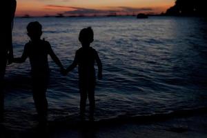 familj av tre silhuett i de solnedgång på boracay strand foto