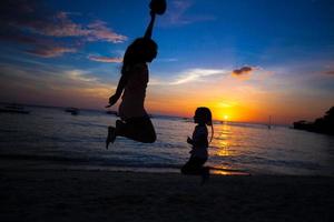 silhuett av mor och liten dotter spelar på de strand i boracay, filippinerna foto