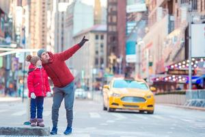 familj av far och liten unge på gånger fyrkant under deras semester i ny york stad foto