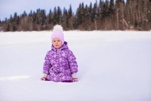 liten flicka i snö vinter- solig dag foto