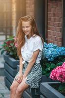 förtjusande mode liten flicka utomhus i europeisk stad foto