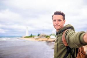 turist man utomhus- på kant av klippa havsstrand foto