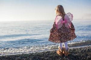 förtjusande liten flicka har roligt på de strand i en vinter- solig dag foto