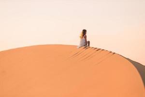 flicka bland sanddyner i öken- i förenad arab emirates foto