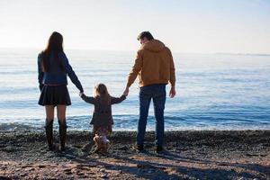 familj på vild strand under de värma vinter- foto