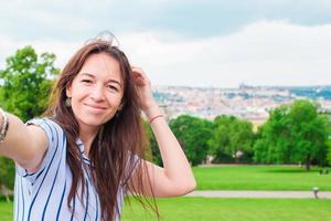 ung caucasian kvinna framställning selfie bakgrund europeisk gammal stad förbi mobil telefon från de observation plats foto