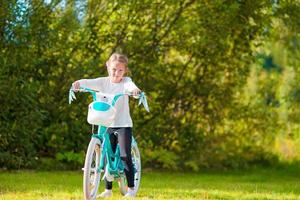 förtjusande flicka ridning en cykel på skön sommar dag utomhus foto