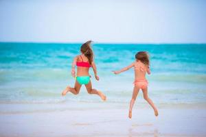 barn har roligt på tropisk strand under sommar semester foto