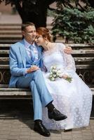 brud i en ljus bröllop klänning till de brudgum i en blå kostym foto