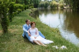 brud i en ljus bröllop klänning till de brudgum i en blå kostym foto