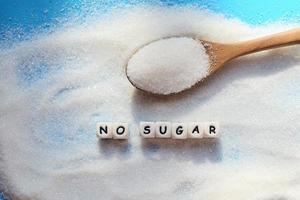 Nej socker begrepp, socker på sked och fläck bakgrund, vit socker för mat och sötsaker efterrätt godis högen av ljuv socker kristallin granulerad foto