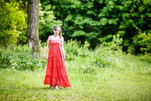 skön älva flicka i röd klänning i de skog. skog fantasi fe- berättelse foto