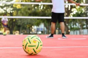 sepak takraw boll på röd golv av utomhus- domstol, suddig bakgrund, rekreationell aktivitet och utomhus- sporter i sydöst asiatisk länder begrepp. foto