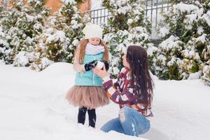 Lycklig familj av mamma och unge njut av vinter- snöig dag foto