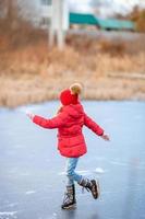 förtjusande liten flickor skridskoåkning på de isbana foto