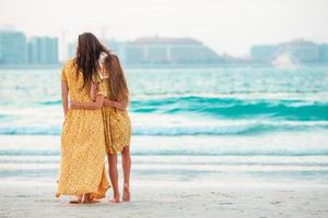 skön mor och dotter på de strand njuter sommar semester. foto
