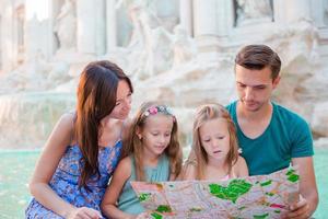 familj med turistiska Karta nära fontana di trevi, rom, Italien. Lycklig far och barn njut av italiensk semester Semester i Europa. foto