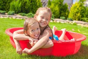 två förtjusande liten Lycklig flickor har roligt i små slå samman utomhus- på sommar dag foto