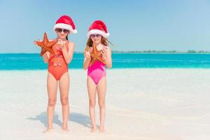 förtjusande liten flickor på jul högtider på de strand foto