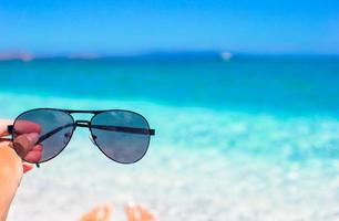 stänga upp av solglasögon på tropisk strand foto
