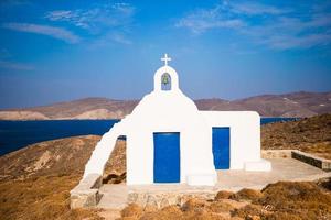 traditionell vit kyrka med hav se i mykonos ö, Grekland foto