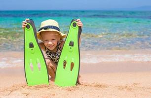 liten flicka med simfötter och glasögon för snorkling på de strand foto