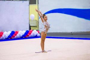 skön liten aktiva gymnast flicka med henne prestanda på de matta foto