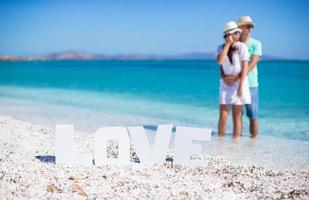 ung Lycklig familj på de strand under sommar semester foto